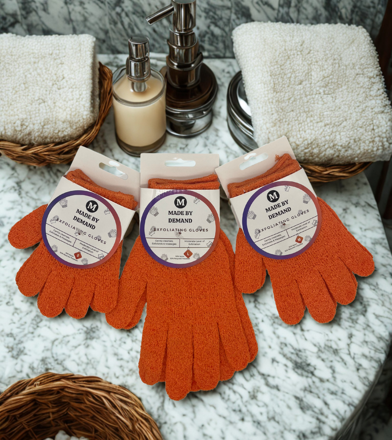 Orange gloves with 'Made by Demand' label on a marble surface with towels and soap.