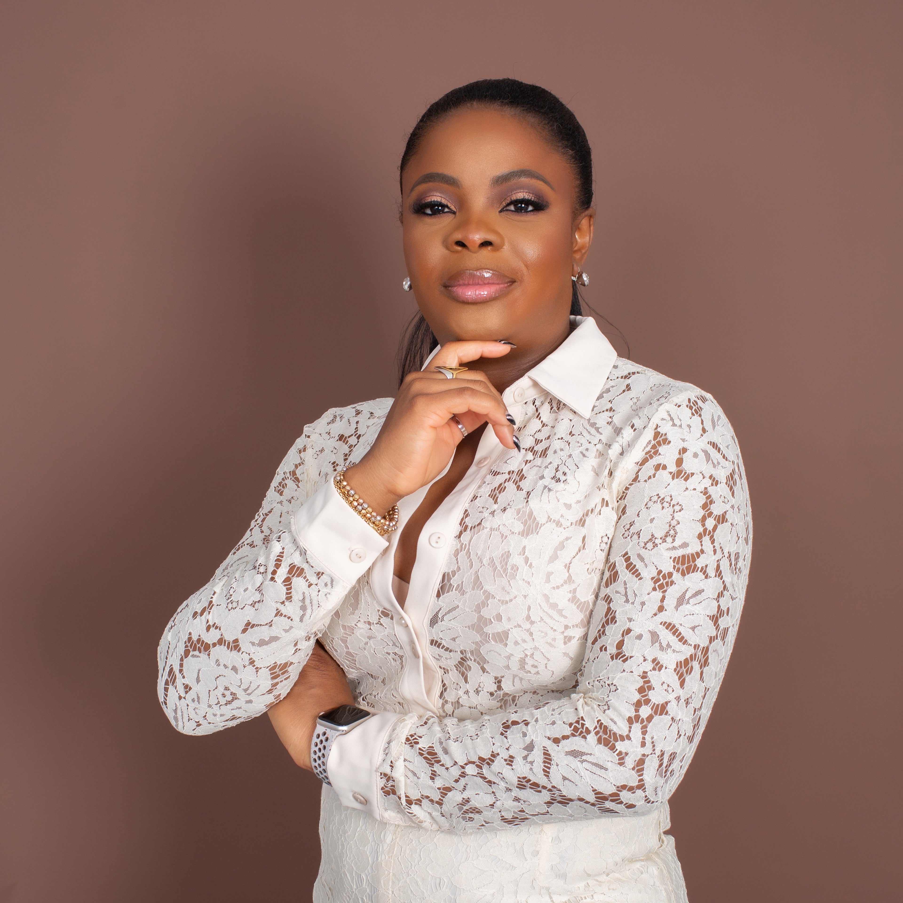 Woman wearing a white lace outfit against a brown background